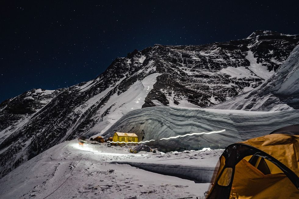 Helmlampen van bergbeklimmers vormen een lichtspoor op de lagere hellingen van de Mount Everest Mensen in het Westen staan z ver van hun familie af Misschien kunnen we deze tijd gebruiken om allemaal eens thuis te blijven zegt Everesttouroperator Jiban Ghimire