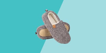 gray fuzzy slippers with a soft interior placed against a light blue background
