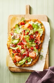 everything seasoning flatbread with cucumber ribbons, smoked salmon, and sliced tomatoes on top