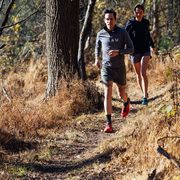 two people running timberland on a trail in the fall