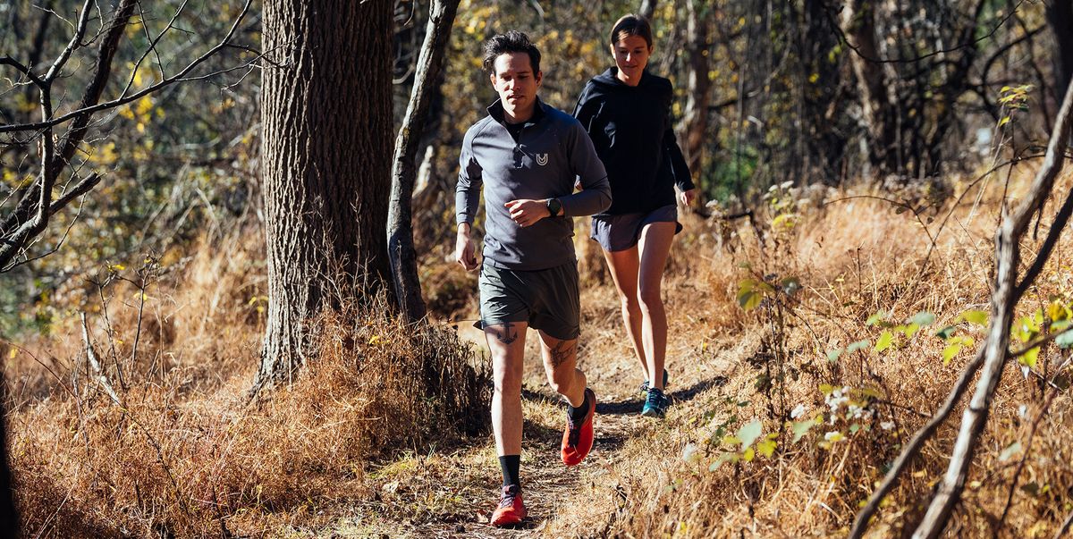 two people running on a trail in the fall