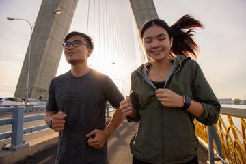 exercise by running in the morning together on walking path at the suspension bridge in the city