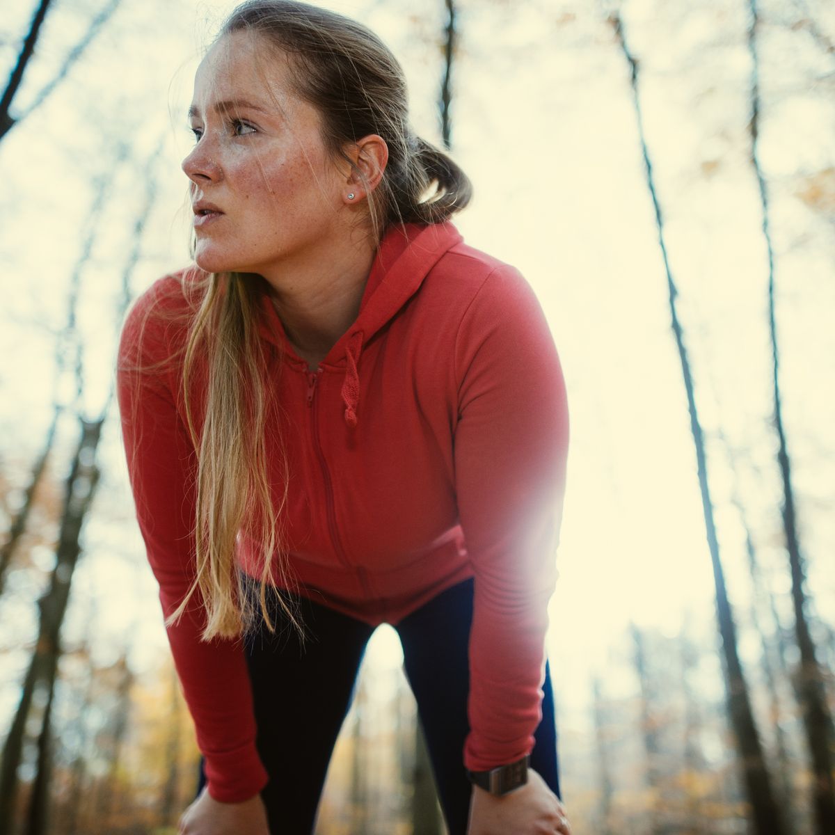 exhausted woman after jogging in autumnal park