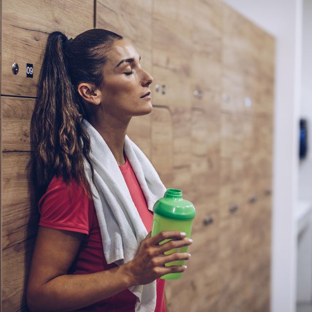 Exhausted woman in locker room after sports training.