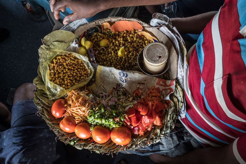 Een straatverkoper bereidt snacks die hij zal verkopen op de langste treinreis door India tussen de steden Kanyakumari en Dibrugarh
