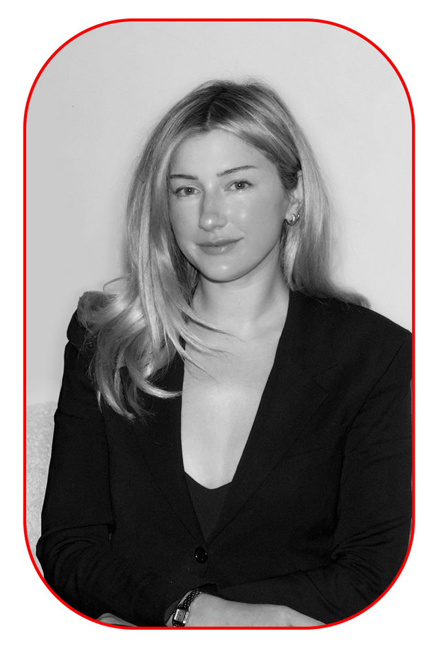 a person wearing a black blazer with a deep neckline sitting comfortably