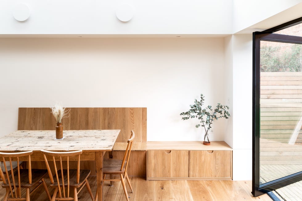 comedor con mesa y sillas de madera, y banco de obra con almacenaje