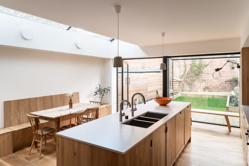 cocina con isla central y comedor, todo en madera