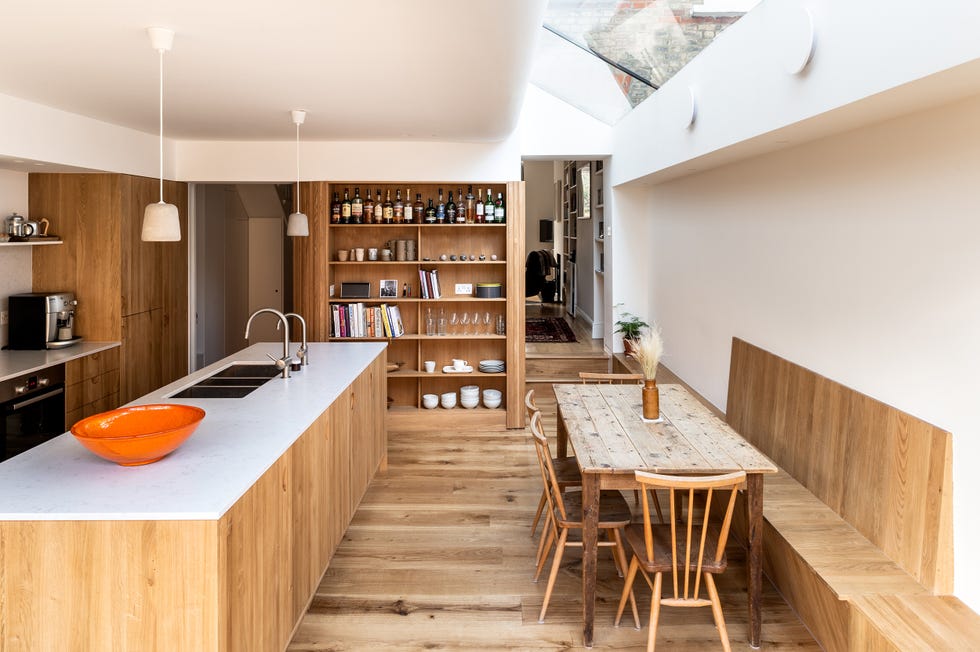 cocina con isla central y comedor, todo en madera