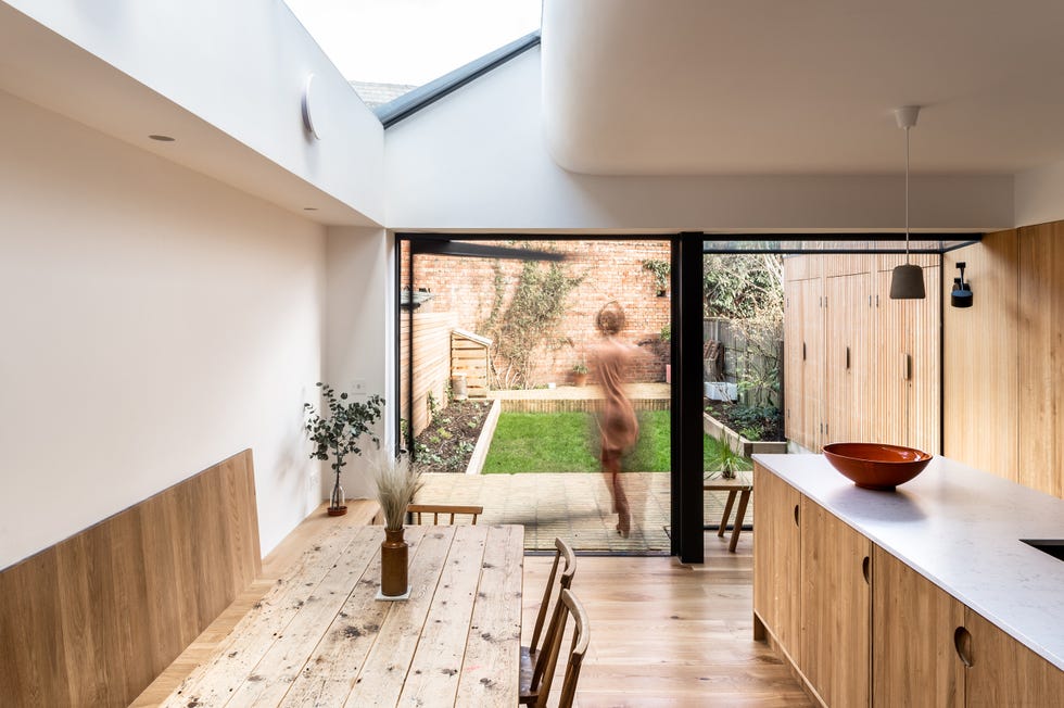 cocina con isla central y comedor, todo en madera
