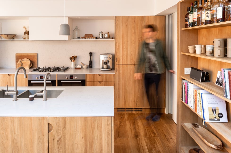cocina de madera con isla central y encimera de mármol a juego con el frente de cocina