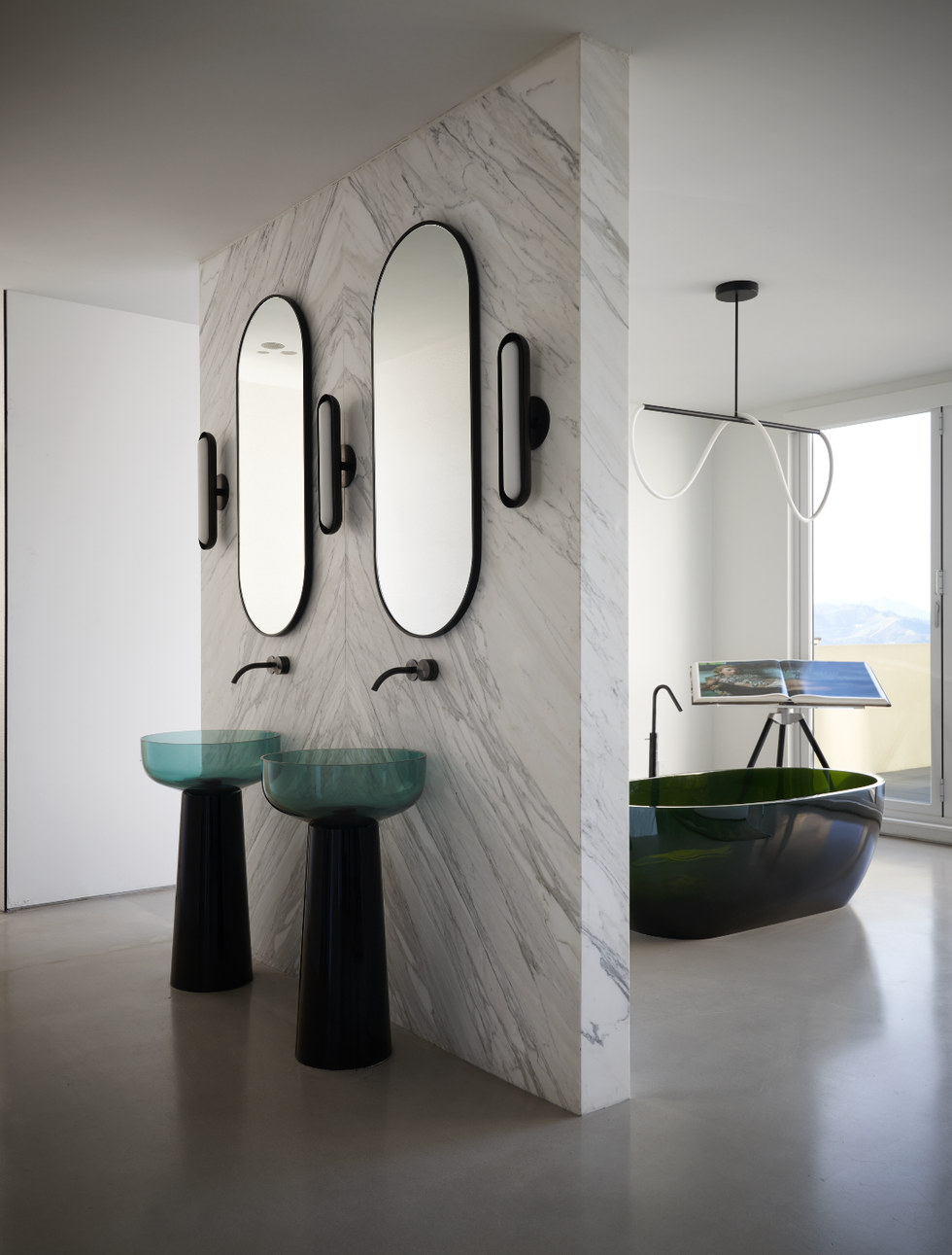 modern bathroom featuring dual sinks mirrors and a freestanding bathtub