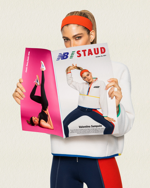 a model wears the staud new balance collaboration while holding up a magazine also featuring models wearing the staud new balance collaboration