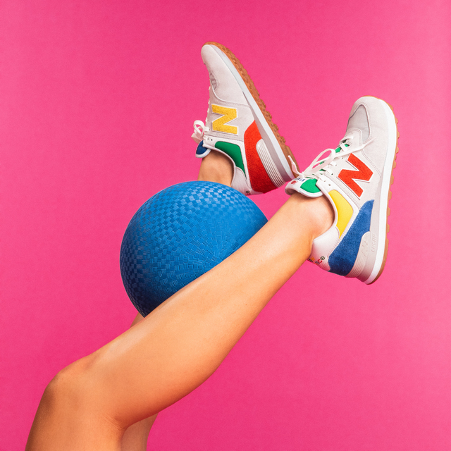 a model wears the staud new balance collaboration sneakers in front of a pink backdrop with a blue rubber ball