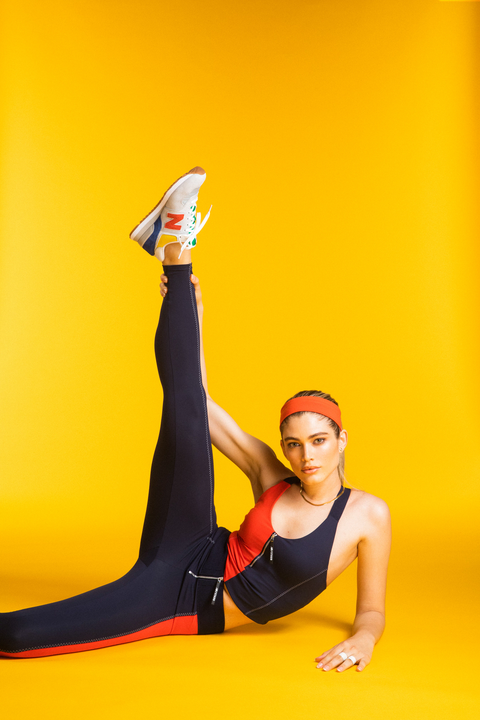 a model wears the staud new balance collaboration in front of a yellow background