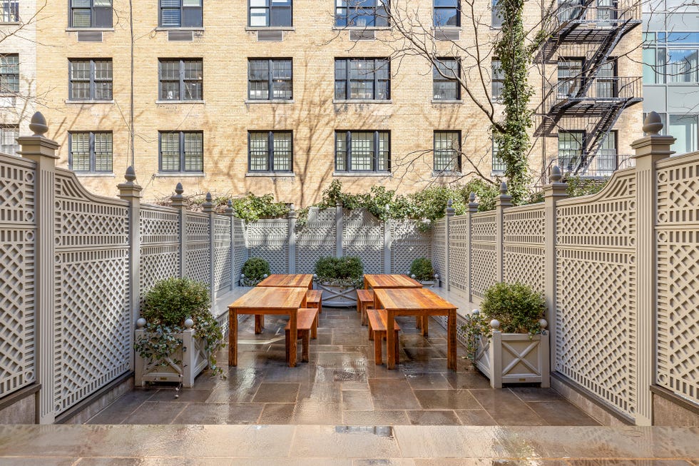 Outdoor dining area with wooden tables and planters.