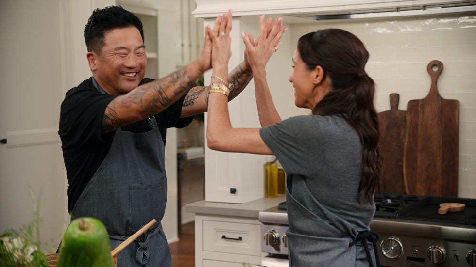Two individuals engaged in a playful interaction in a kitchen setting.