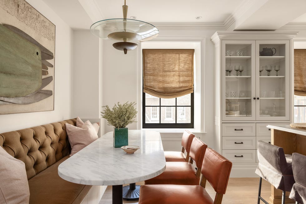 Modern dining area featuring a marble table and upholstered seating.