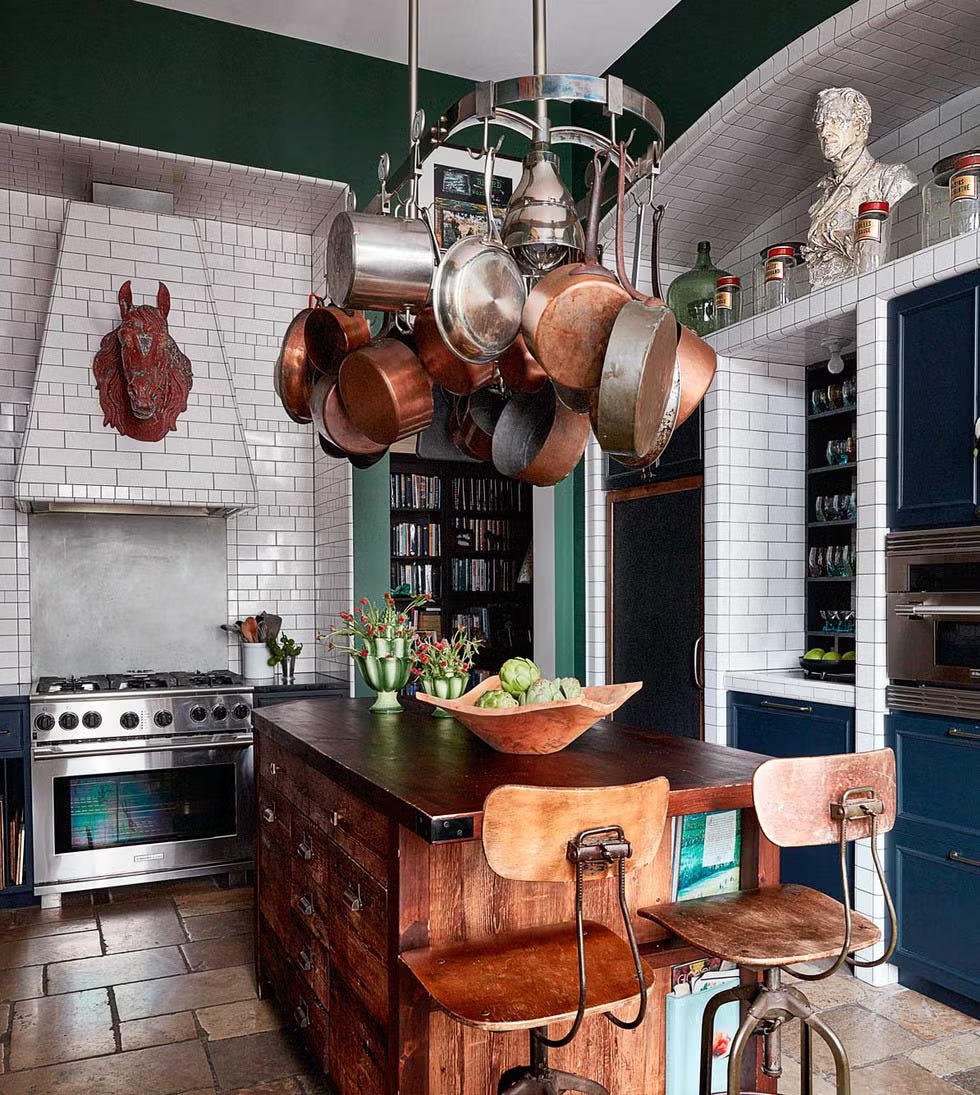 Modern kitchen with cookware hanging from a ceiling rack and a central island