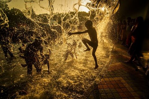 Kinderen spelen in een waterfontein op een warme dag in Hyderabad India Mei is meestal de warmste maand in Hyderabad met temperaturen die gemiddeld rond de 37 graden Celsius liggen