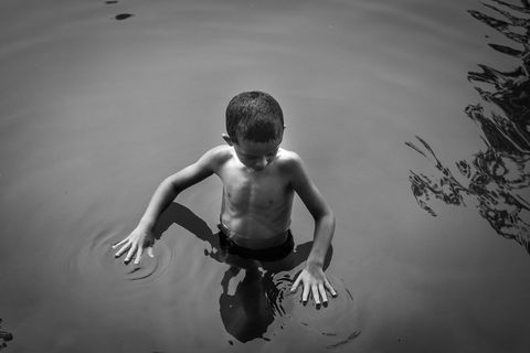 In Chauzon in Frankrijk stopt een jongen even met zwemmen om het wateroppervlak te onderzoeken