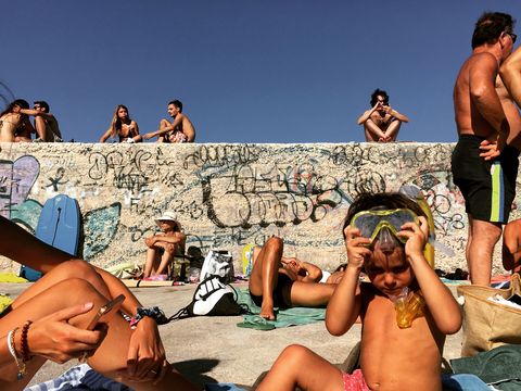 Dit tefereel is vastgelegd in het dorp Tricase Porto een pittoreske haven aan de kaap van Puglia zegt Your Shotfotograaf Lorenzo Grifantini Op deze kleine pier heerst een gevoel van tijdloosheid waarin een mix van lokale mensen duikt zwemt en geniet van het samenzijn