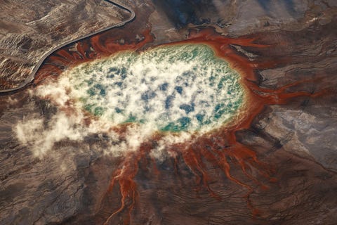 De zon komt op boven de beroemde Grand Prismatic Spring in Yellowstone National Park De zonsopgang verlicht deze scne en kleuren perfect en accentueert ze zegt Your Shotproducer David Y Lee De Grand Prismatic Spring is de grootste hot spring in de Verenigde Staten