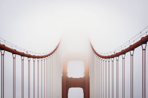 Twee grote iconen uit San Francisco komen samen in deze foto de Golden Gate Bridge en de mist De hoogste punten van de brug zijn 227 meter hoog  even hoog als bijna 69 verdiepingen