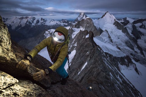 Een klimmer verandert van positie op de rand van Zinalrothorn een van de toppen van de Zwitserse Alpen Achter haar zie je de Matterhorn een van de beroemdste bergen ter wereld