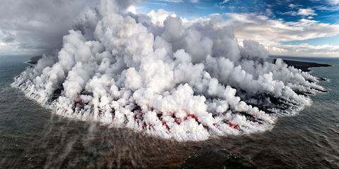 Stoom en rook stijgen de lucht in terwijl lava uit de Klauea de Grote Oceaan in stroomt naast het grote eiland Hawaii De vulkaan is een van de meest actieve ter wereld onlangs begon hij in mei 2018 met uitbarsten