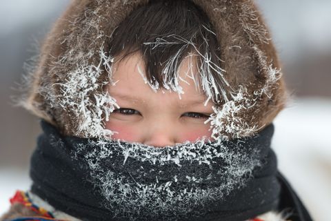 Een jonge Nenetsjongen wordt goed aangekleed tegen de kou in Kharp Rusland De Nenets zijn nomaden afkomstig uit het noorden van Rusland
