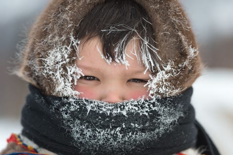 Een jonge Nenetsjongen wordt goed aangekleed tegen de kou in Kharp Rusland De Nenets zijn nomaden afkomstig uit het noorden van Rusland