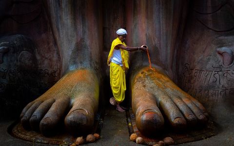 In de Indiase stad Shravanabelagola wast een gelovige de voeten van het standbeeld van Bahubhali Bahubhali betekent Een met Sterke Armen en is een veel aanbeden figuur in het Janistische geloof Het beeld is 17 meter hoog en gehouwen uit n stuk steen