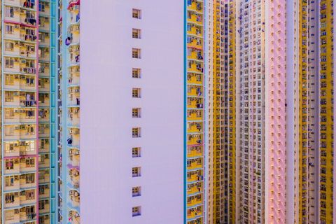 Hong Kong heeft een bevolkingsdichtheid van 25870 mensen per vierkante kilometer Om ze allemaal te huisvesten staan er in het stadscentrum enorme felgekleurde appartementencomplexen