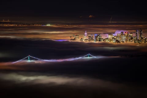 De stad Vancouver in British Columbia steekt uit boven een mistige winternacht Fotografen snellen vaak naar Cypress Mountain voor een uitkijkpunt boven de dichte mist zegt Your Shotfotograaf Spencer Finlay Ik ben hier vaak geweest om vervolgens niets te zien omdat de hele stad in dikke nevel was gehuld Deze januarinacht werd ik verrast en zag ik de iconische Lions Gate Bridge en de herkenbare skyline van Vancouver uit de verlichte deken van mist steken