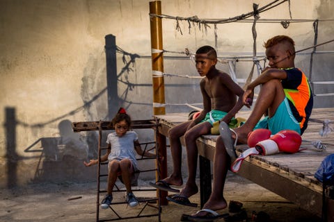 Na een bokstraining luisteren twee jongens en hun ook aanwezige zusje naar de peptalk van hun coach zegt Your Shotfotograaf P Warner Met de beperkte middelen die in Havana aanwezig zijn vinden we de boksring buiten een gebouwencomplex gemaakt van overgebleven materialen uit huizen