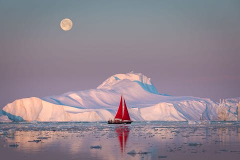 Een zeilboot steekt af tegen het witte canvas van een ijsberg De vredigheid en schoonheid van dit moment was het waard om uren op een zeilboot in Disko Bay in Groenland te varen zegt Your Shotfotograaf Kati Seiffer Ik heb mezelf nog nooit zo relaxed gevoeld