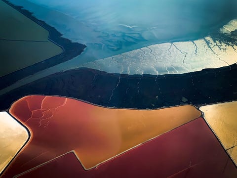 Een luchtfoto laat de abstracte schoonheid van de zoutvijvers in San Francisco Bay zien Het water verandert van kleur naarmate het zouter wordt Uiteindelijk wordt het zout geoogst en verspreid