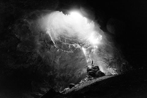 A traveler basks in the dramatic light of Jomblang Cave in Indonesia The only way into the vertical cave is to rappel approximately 300 feet underground