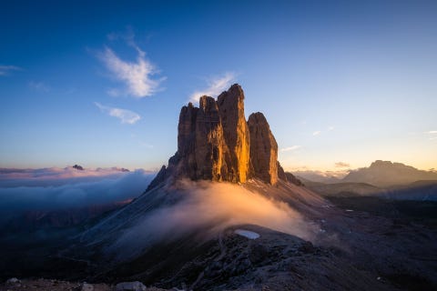 De zon gaat onder bij de Tre Cime di Lavaredo een bekende en onderscheidende berggroep in de Alpen De naam is Italiaans voor de drie pieken van Lavaredo