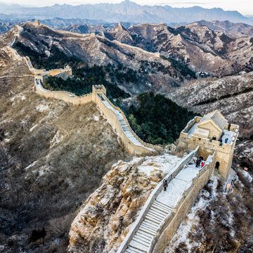 Het ochtendlicht schijnt op de Chinese Muur Hoewel de muur inderdaad duizenden kilometers lang is is het een mythe dat de structuur vanuit de ruimte zichtbaar zou zijn
