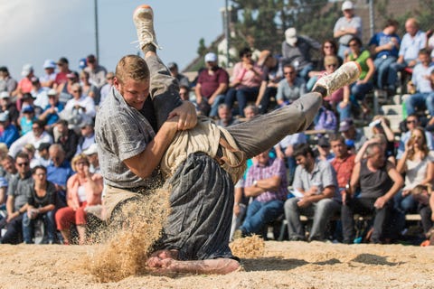 Twee mannen houden zich bezig met een partijtje Schwingen ofwel Zwitsers worstelen De traditionele sport gaat eeuwen terug Bij elke ronde proberen de tegenstanders elkaars Schwingerhosen of worstelbroeken te grijpen en gooien ze elkaar op de grond De eerste persoon wiens schouders de grond raken verliest