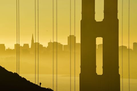 De Golden Gatebrug baadt in het licht van het gouden uur met de skyline van San Francisco op de achtergrond