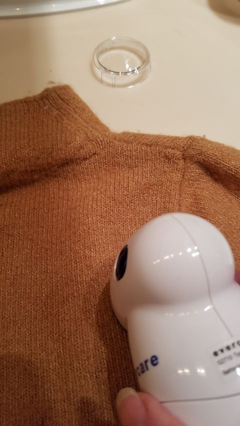 using evercare fabric shaver on a brown sweater