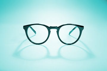 studio shot of black glasses with long shadow at pink background