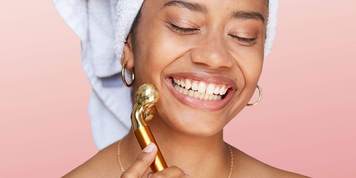 woman rolling face with gold massager