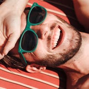 This is an image man with green sunglasses sunbathing