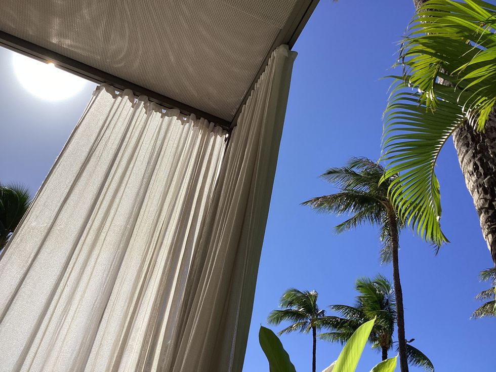 author's personal photo of view from inside of pool cabana looking out at sky