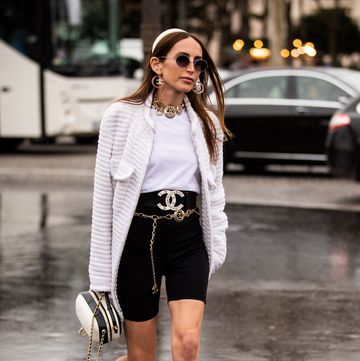 paris, france march 05 chloe harrouche, wearing a white t shirt, black biker shorts, chanel belt, white heels, white jacket, black and white bag and white hairband, is seen outside chanel on day 9 paris fashion week autumnwinter 201920 on march 5, 2019 in paris, france photo by claudio laveniagetty images