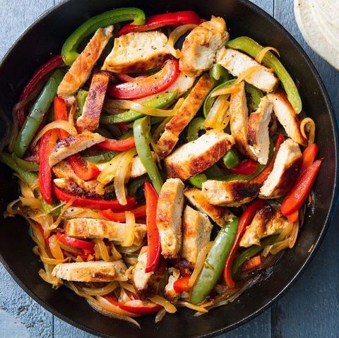 fajita chicken and red and green peppers in a cast iron skillet